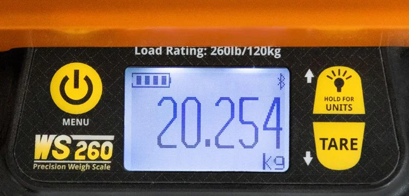 Digital display of a precision weight scale showing 20.254 kilograms