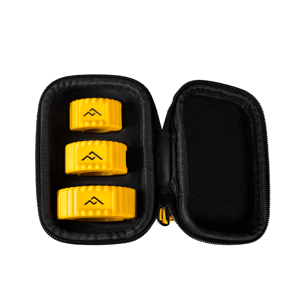 Open black carrying case with three yellow objects inside, each with black symbols, on a black background.