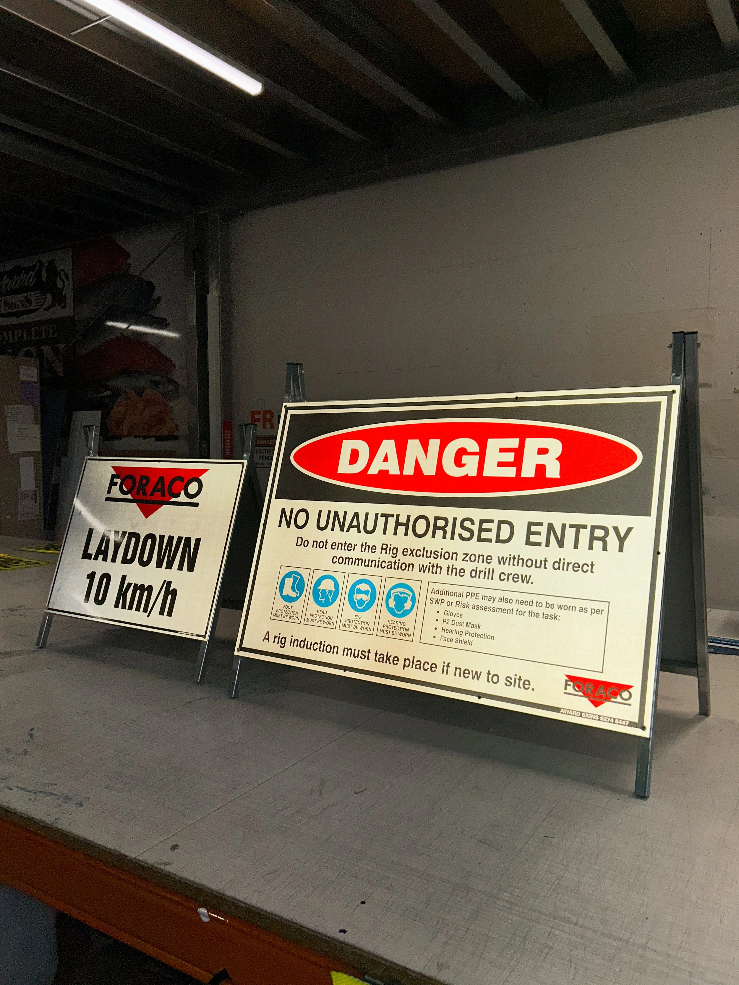 High Visibility Vinyl Safety A-Frame signs indicating danger, no unauthorized entry and instructions for site induction at an industrial site for Foraco Drilling
