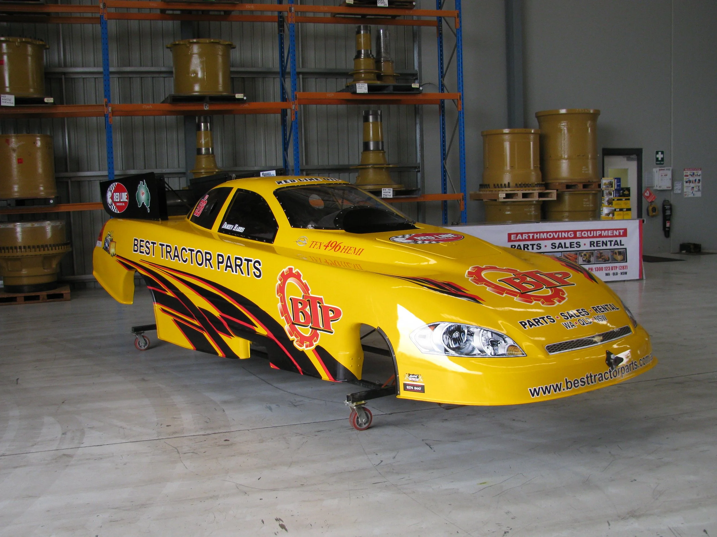 A yellow drag racing car with BTP Best Tractor Parts sponsorhip decals and other motorsport sponsors and racing decal liveries