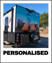Rear of a caravan with a custom decorative mural showing cartoon Emus and a sunset. Personalised Caravan. Caravan Decals. Custom Caravan