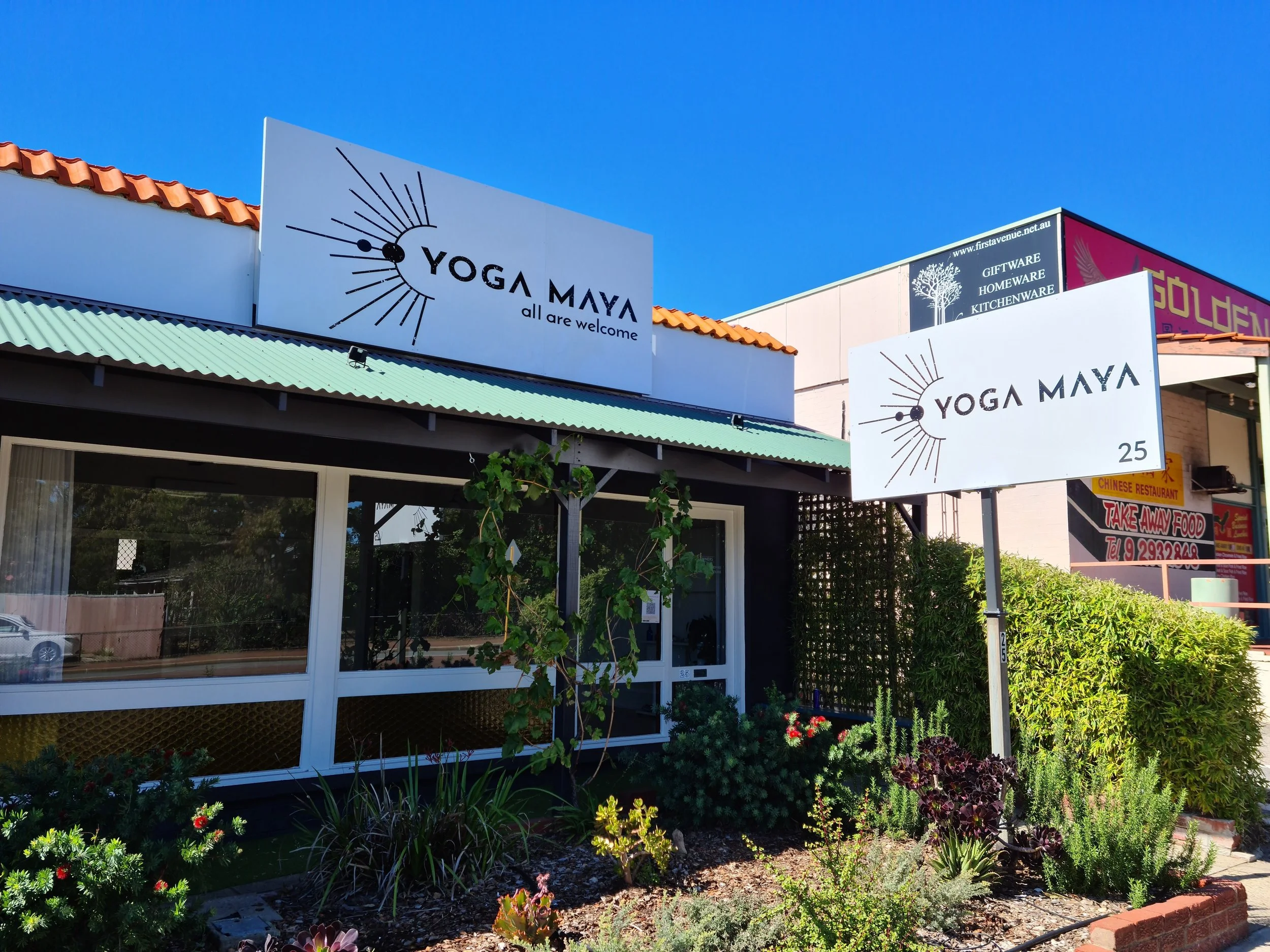 Exterior of a building with signs for Yoga Maya. Commercial signage