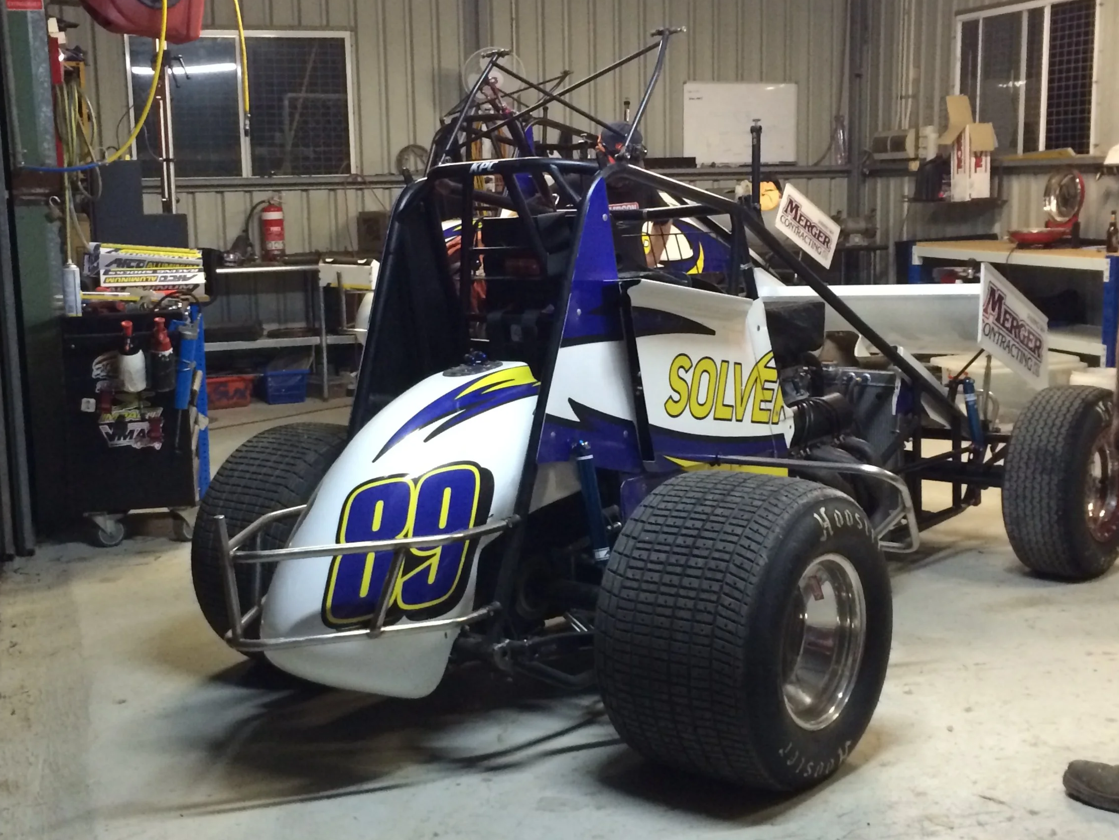 A dirt track racing car with the number 91  and motorsport sponsors and decals