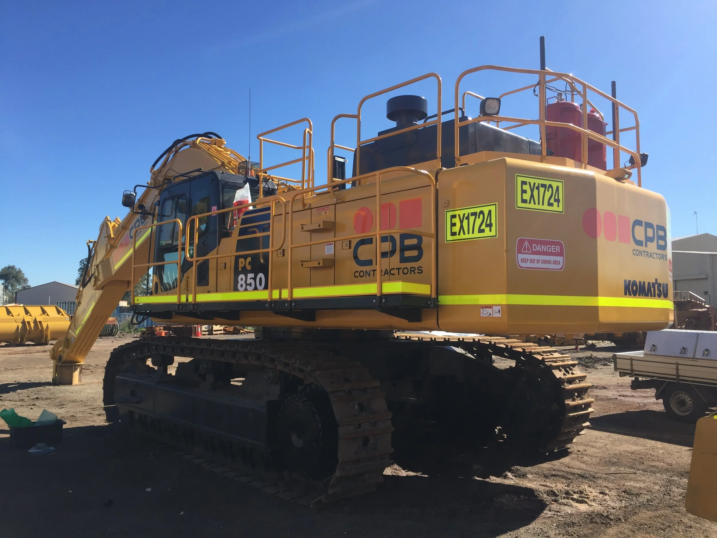 A large yellow mining excavator with CPB Branding, High Visibility DG3 Striping and Asset Numbers