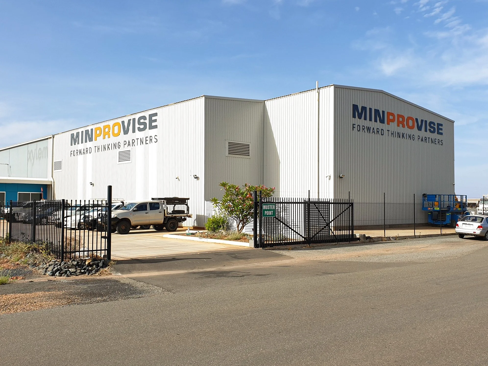 Exterior of a large industrial building with large signage 'MINPROVISE Forward Thinking Partners'; Commercial business signage