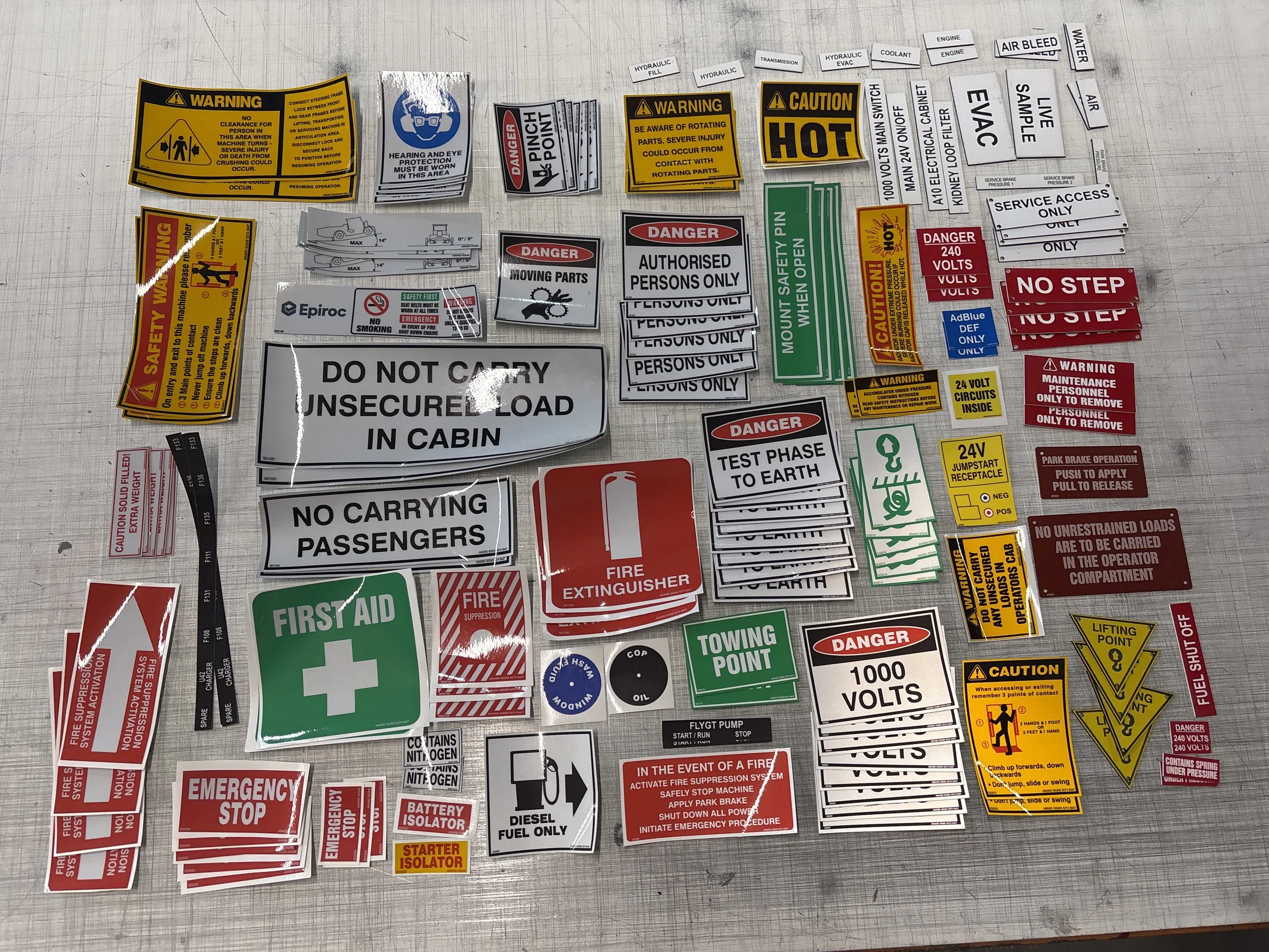 Kit of safety and warning label and decals, including signs for electrical hazards, fire safety, and equipment instructions. Safety deacals and signage