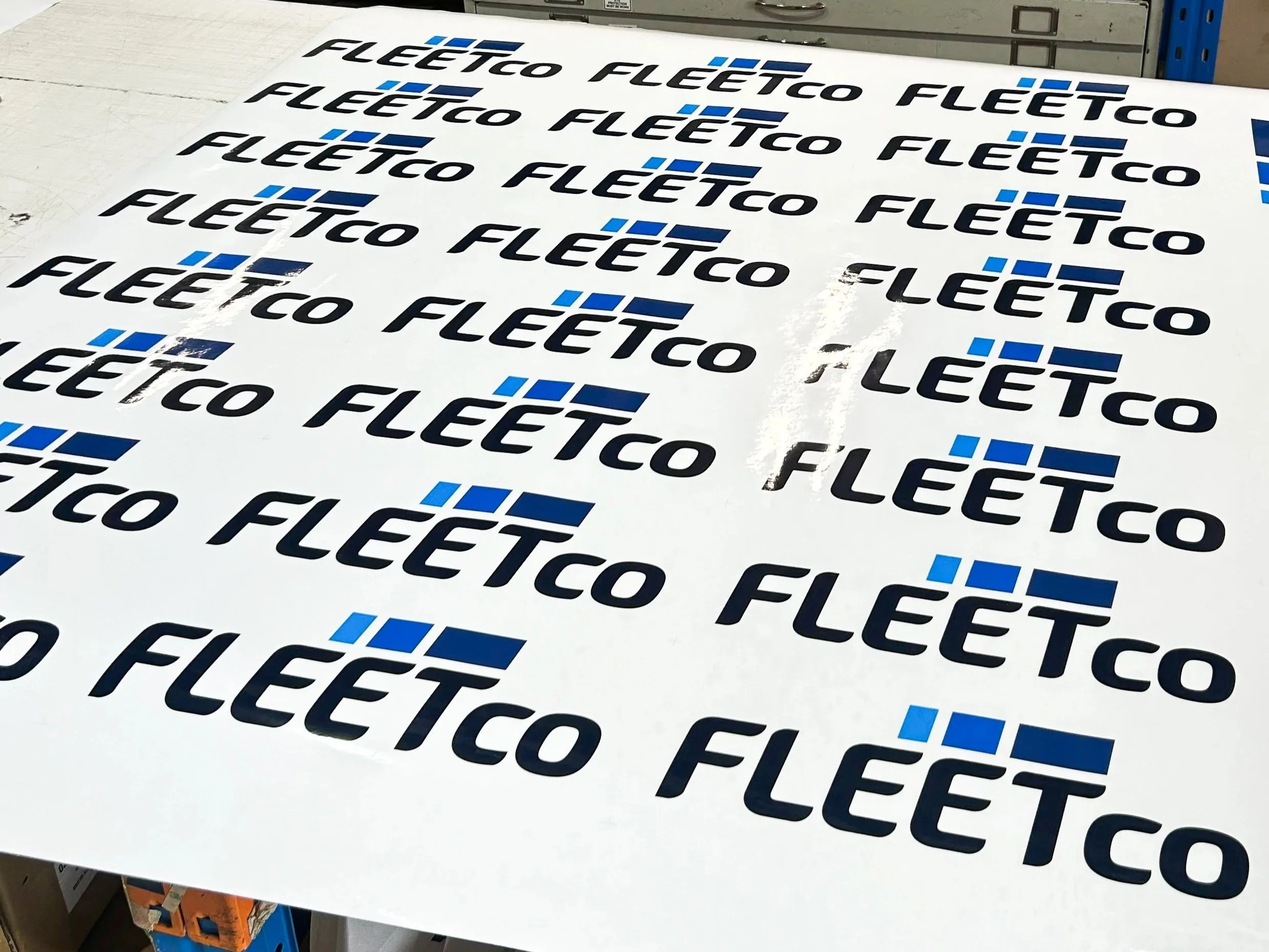 Multiple Fleetco logos on a white surface, with black and blue text and design elements.