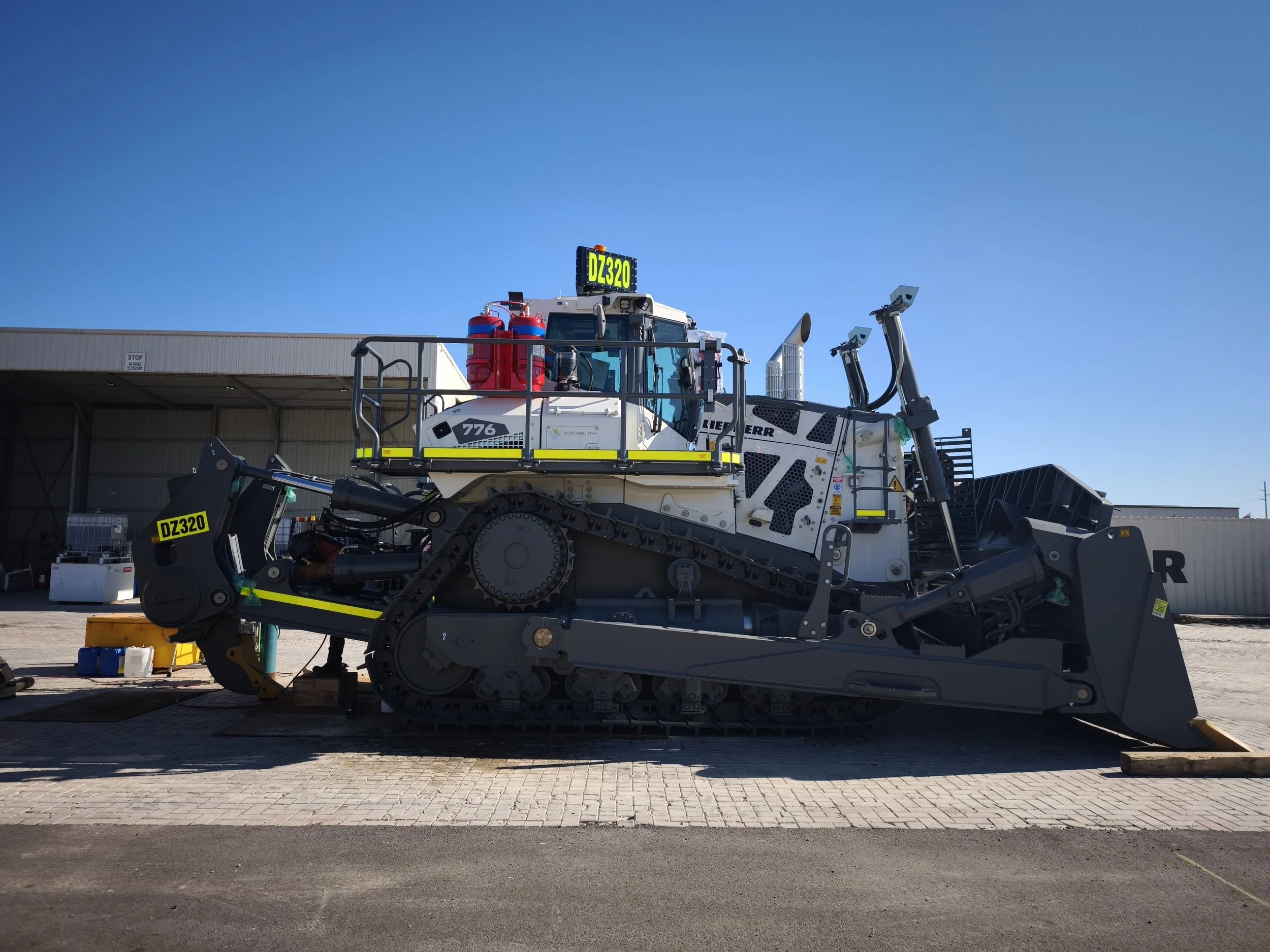 A large white industrial machine high-visibility DG3 striping and Asset Numbers.
