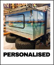 A mobile aquarium exhibit on wheels showing a large glass tank filled with water, seaweed, and fish.