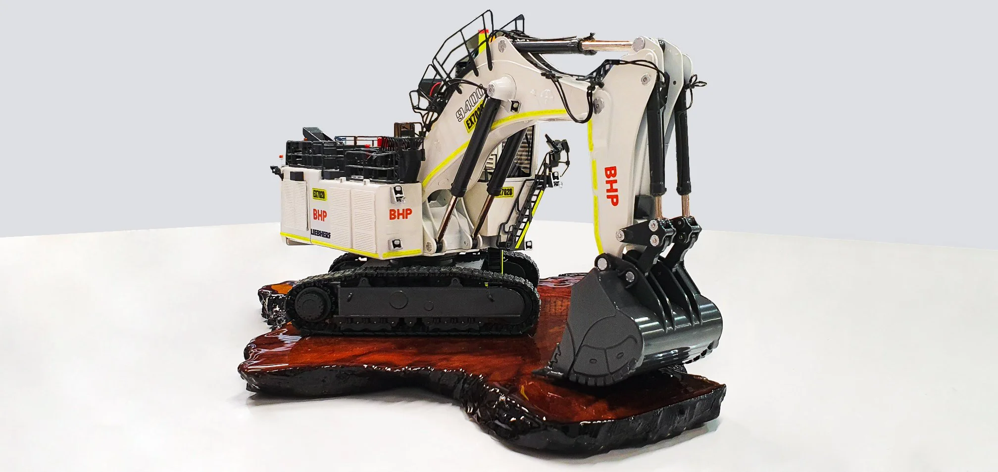 A detailed model of a mining excavator on a polished wooden base. Custom mining gifts