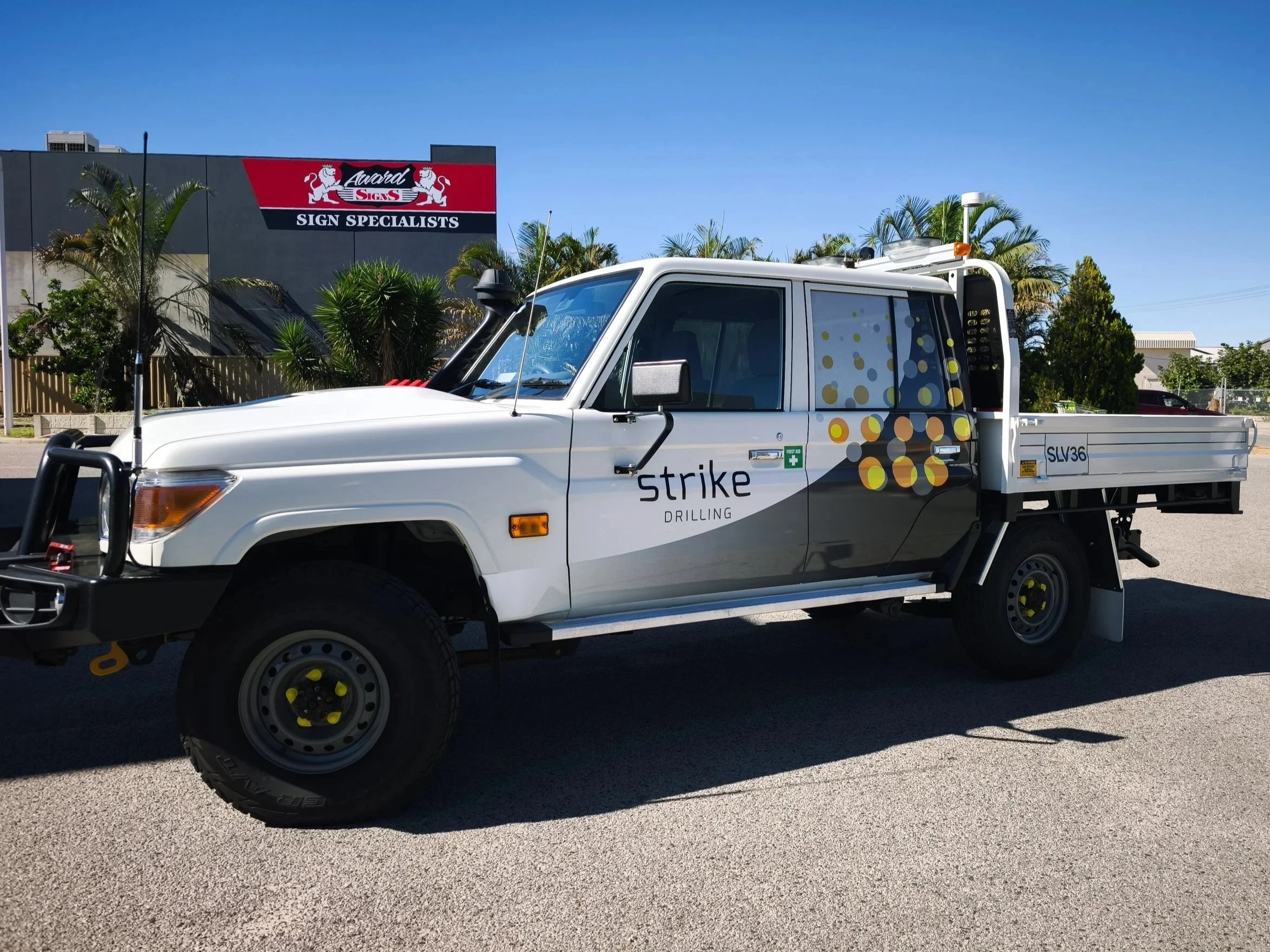 A 79 Series Toyota Landcruiser with Strike Drilling Signage and Partial Wrapping with Asset Numbers. Fleet Vehicle Branding