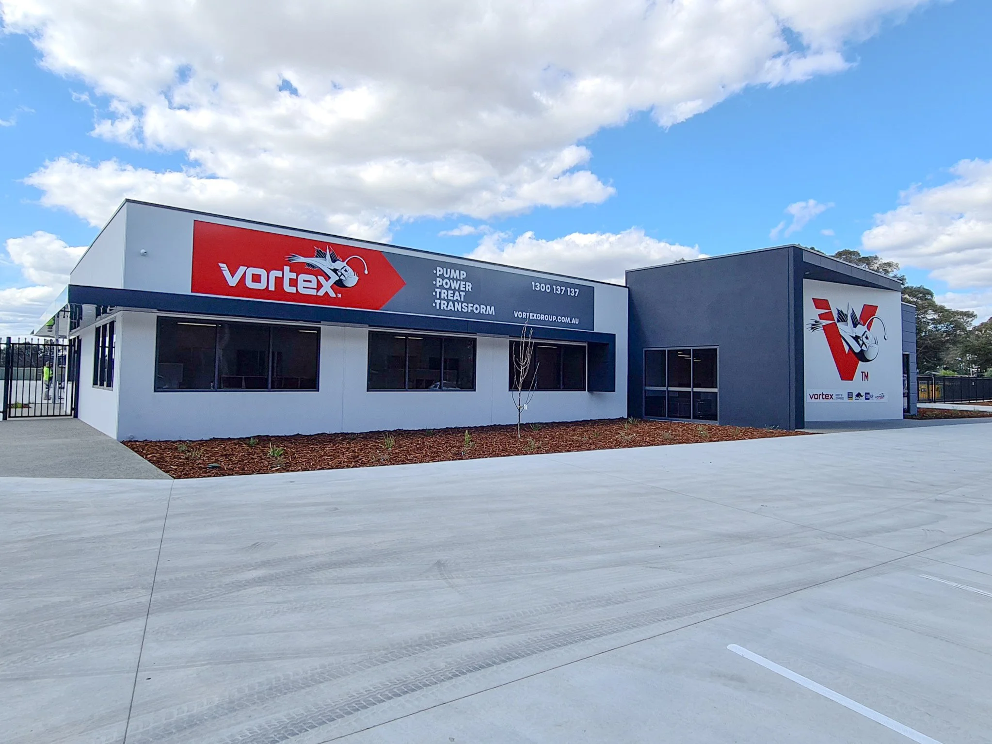 A commercial building with a large sign reading 'Vortex' and a fish logo. Commercial Business Signage and Branding