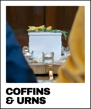 a couple standing in the foreground with a coffin in the background - custom wrapped coffins and urns for funerals