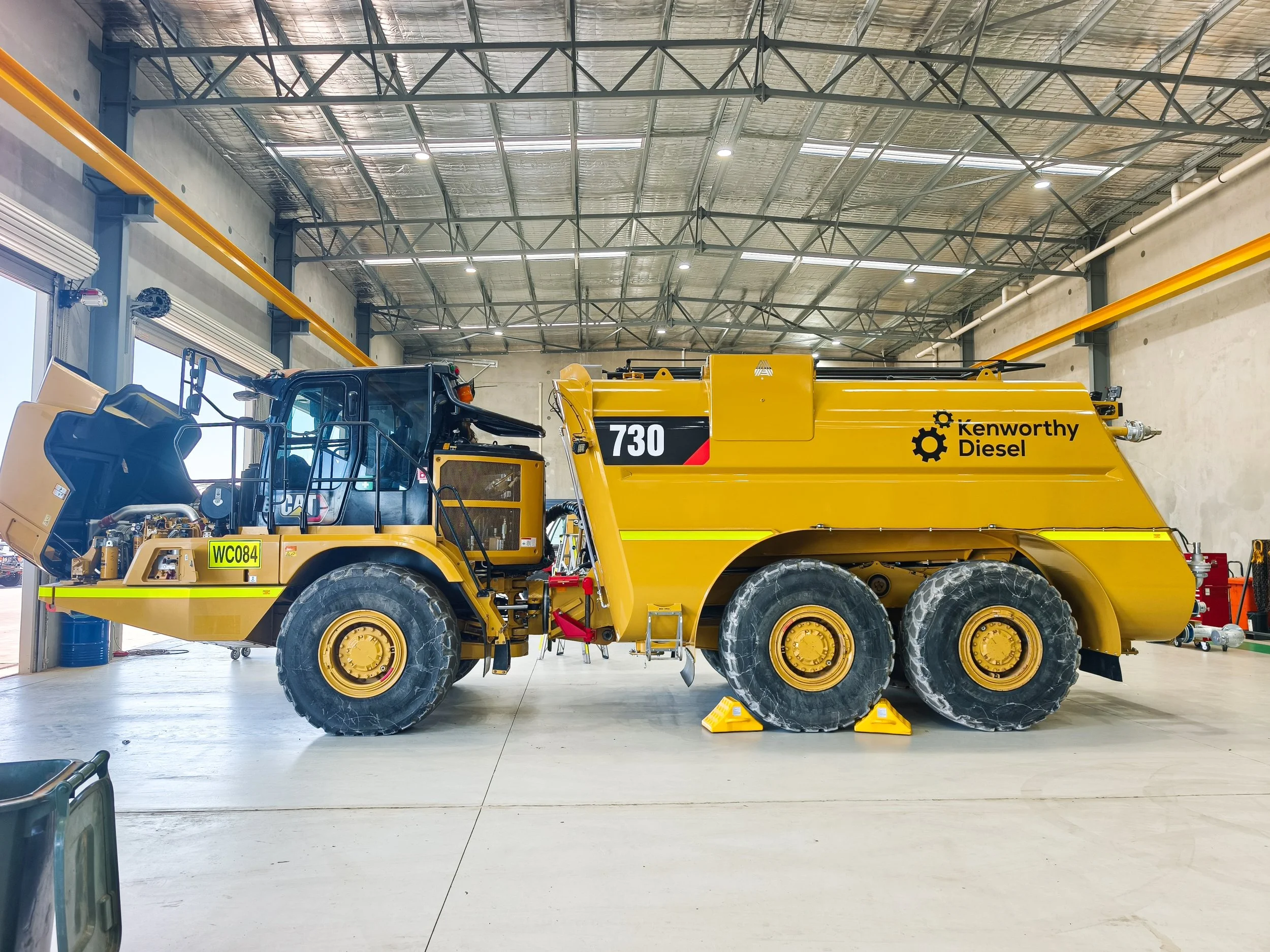 A large CAT Watercart with Kenworthy Diesel Branding and high-visibility DG3 striping. Fleet Branding - Industrial Branding