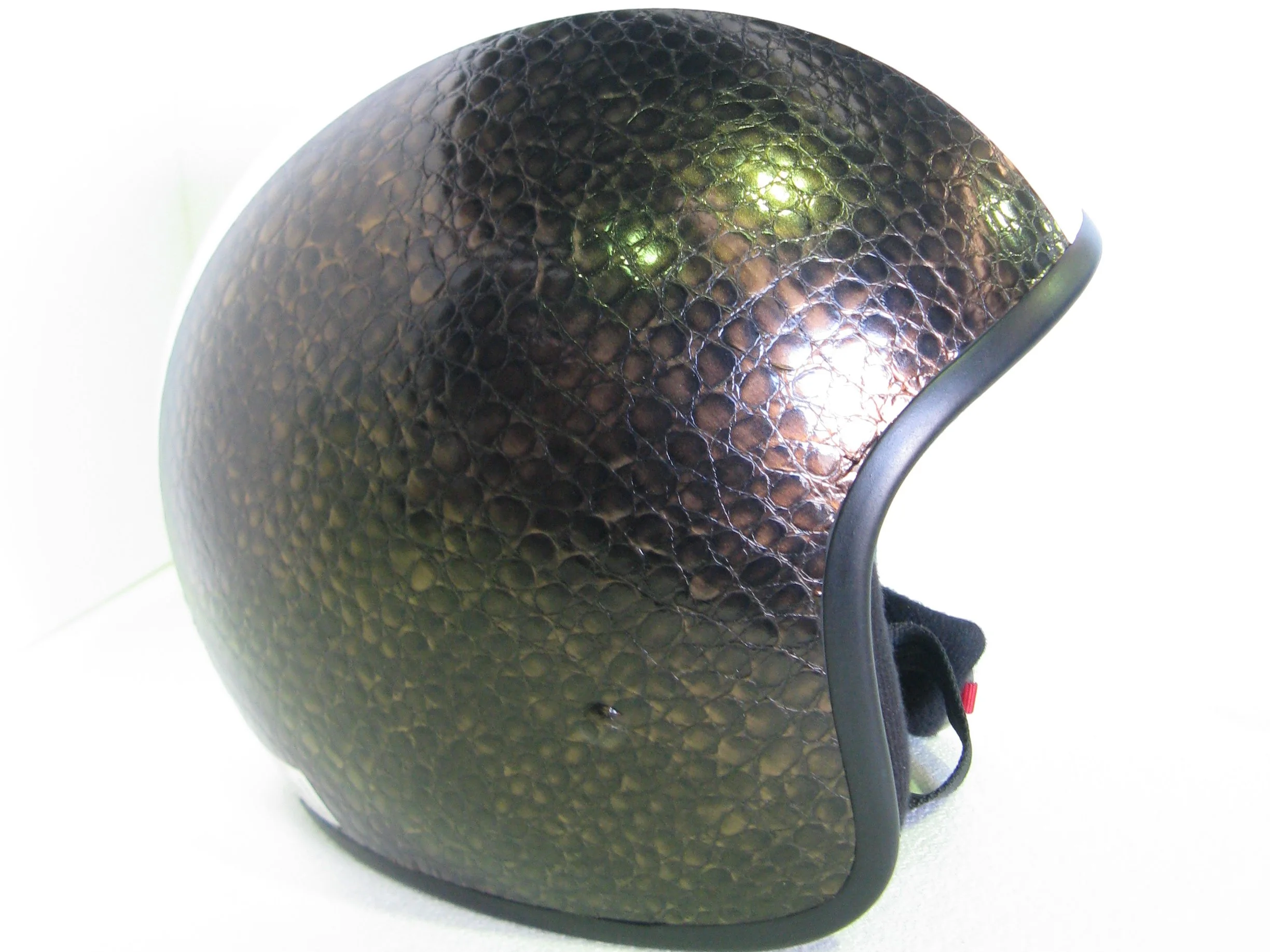 Close-up of a black textured motorcycle helmet with a glossy finish, showing details of the surface pattern and a section of the visor.