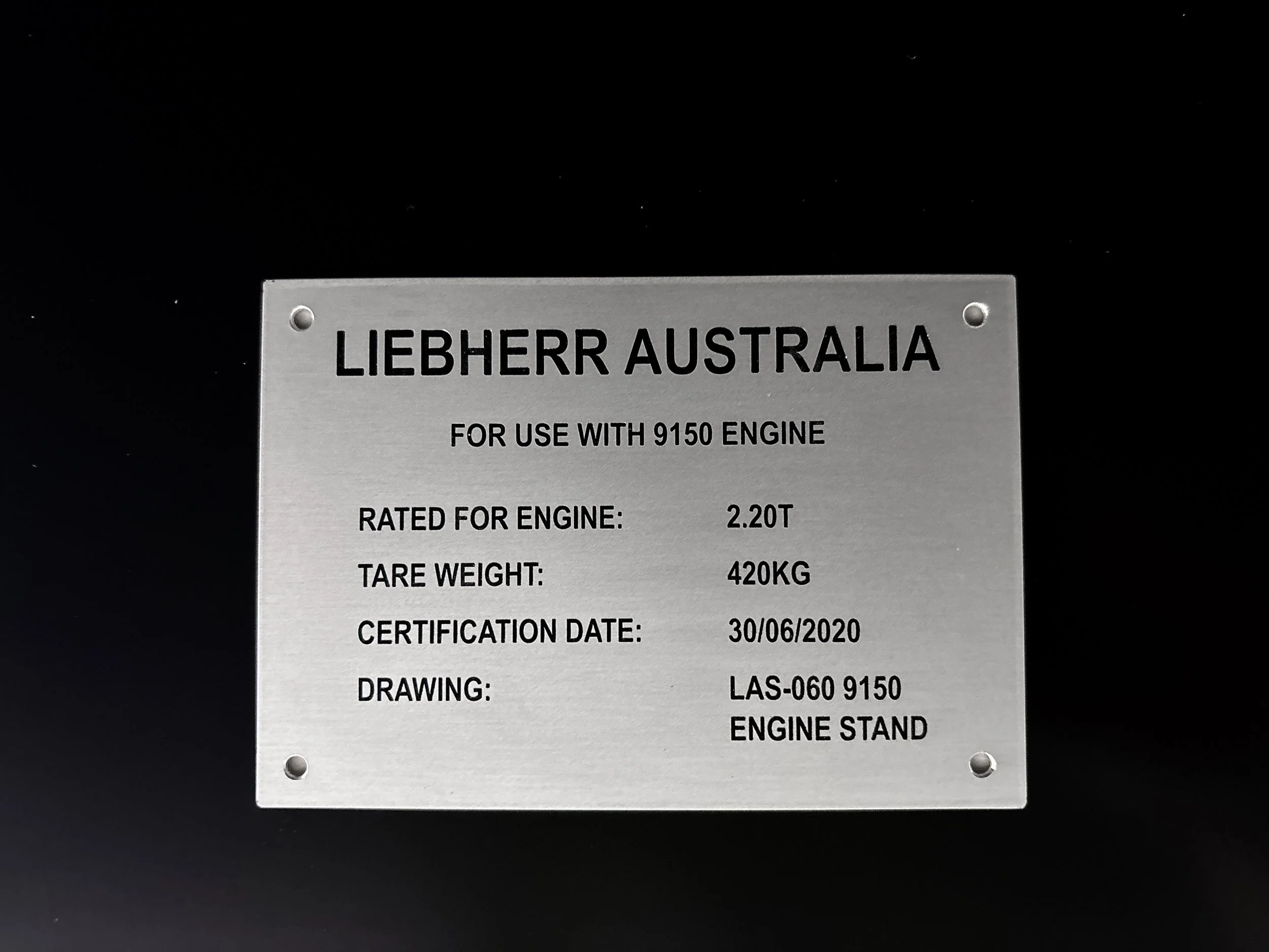 A custom metal identification VIN plate with engraved black filled text "Liebherr Australia" and engine specifications. Custom Vehicle Tags Perth, Custom Engraved Tags Welshpool, Mining Tags Newman, Custom Engraved Etched Sign. Engraving
