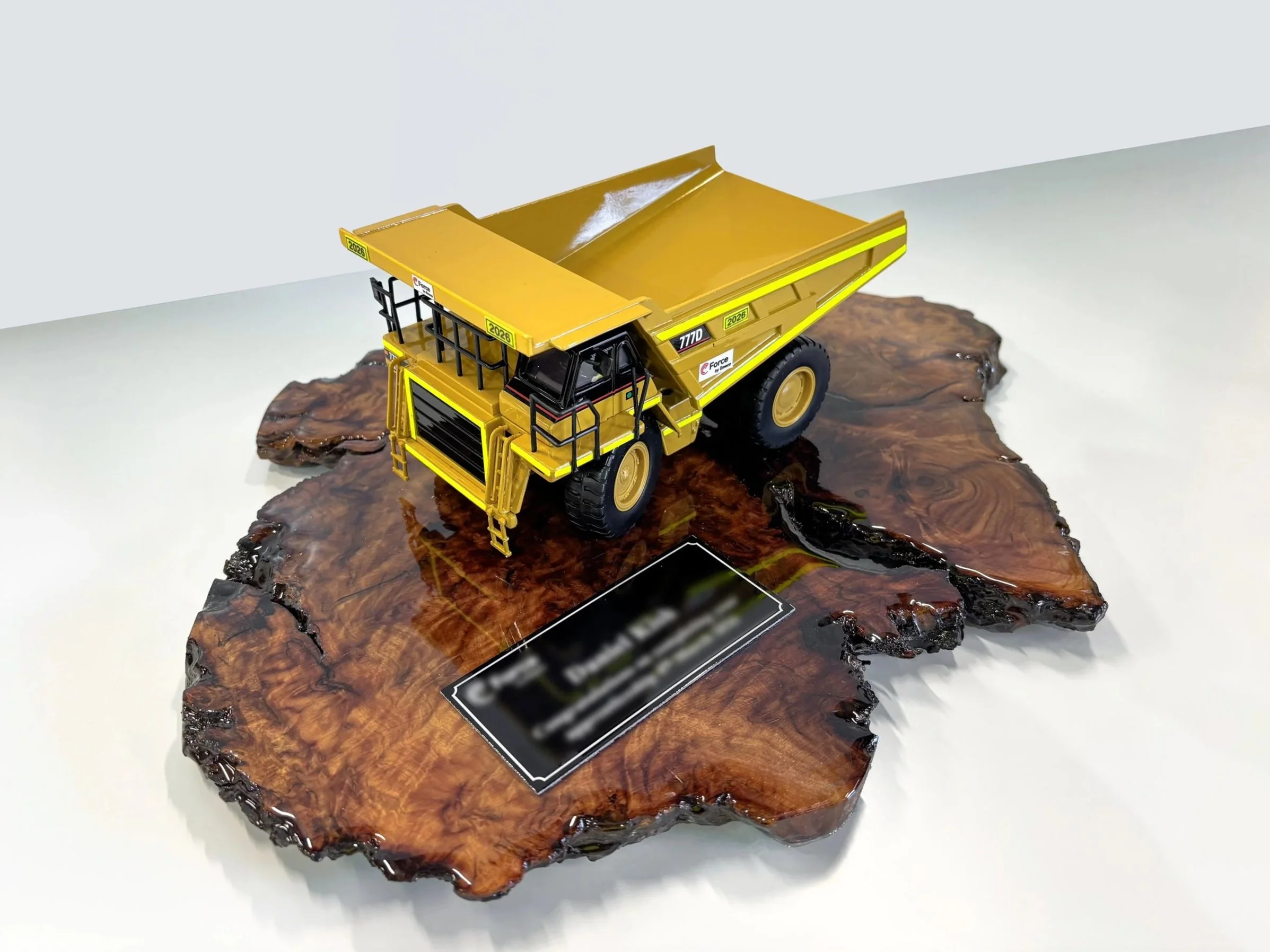 Model toy dump truck on a polished wooden surface. Custom mining gifts