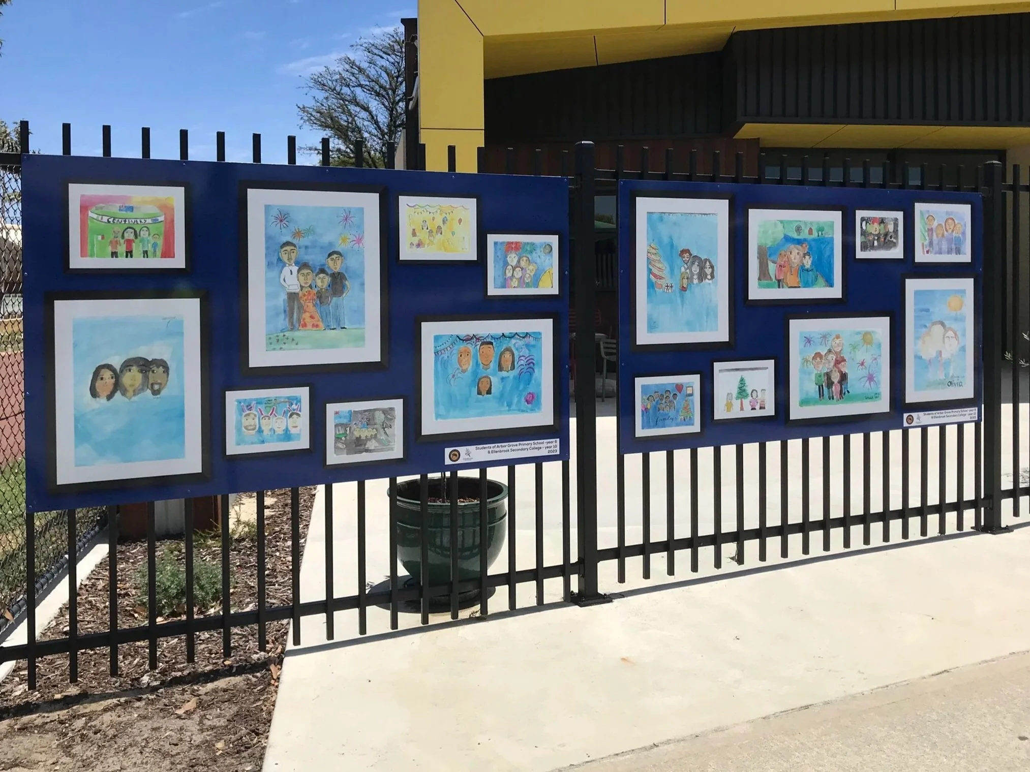 Outdoor art display on a blue fencing board with colorful children's drawings at Brookmount Dr, Ellenbrook WA 6069. Ellenbrook Art Signage. School Signage Ellenbrook. Art Displays Ellenbrook. Education Signage Ellenbrook. Art Displays Perth.