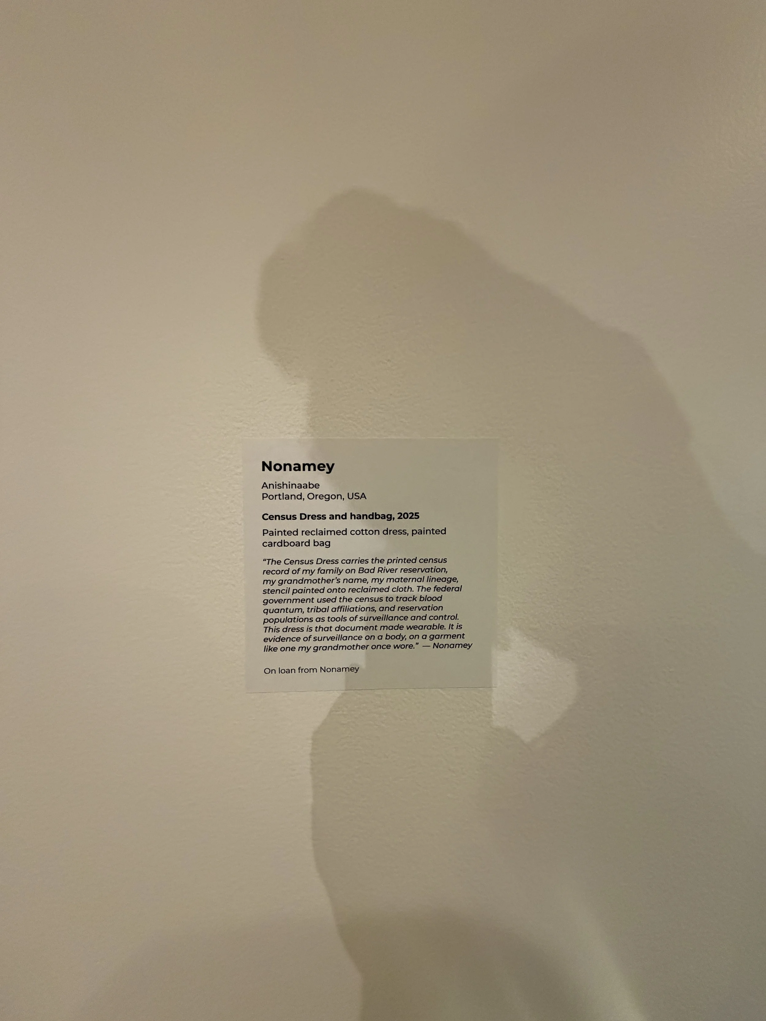 Image: The description for the Dress and bag by designer Nonamey - Anishinaabe, Portland, Oregon, USA. which  speaks to Blood quantum. Blood quantum fractures genealogy, Kauanui (2008).