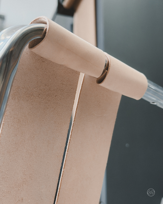 A close-up of a beige paper towel or toilet paper roll on a metallic holder.
