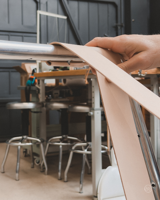 Person assembling or adjusting a piece of furniture or equipment at a workbench in a workshop.