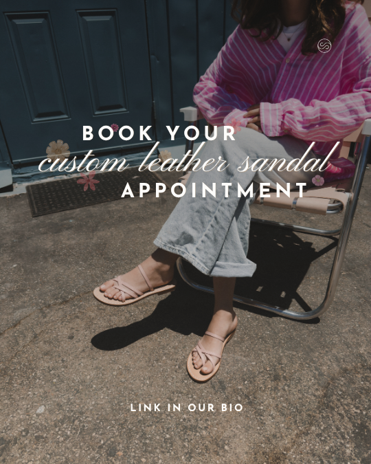 A person sitting outside in front of a blue door, wearing a pink striped shirt, light blue jeans, and custom leather sandal, with text overlay promoting booking a custom leather sandal appointment and linking to their bio.