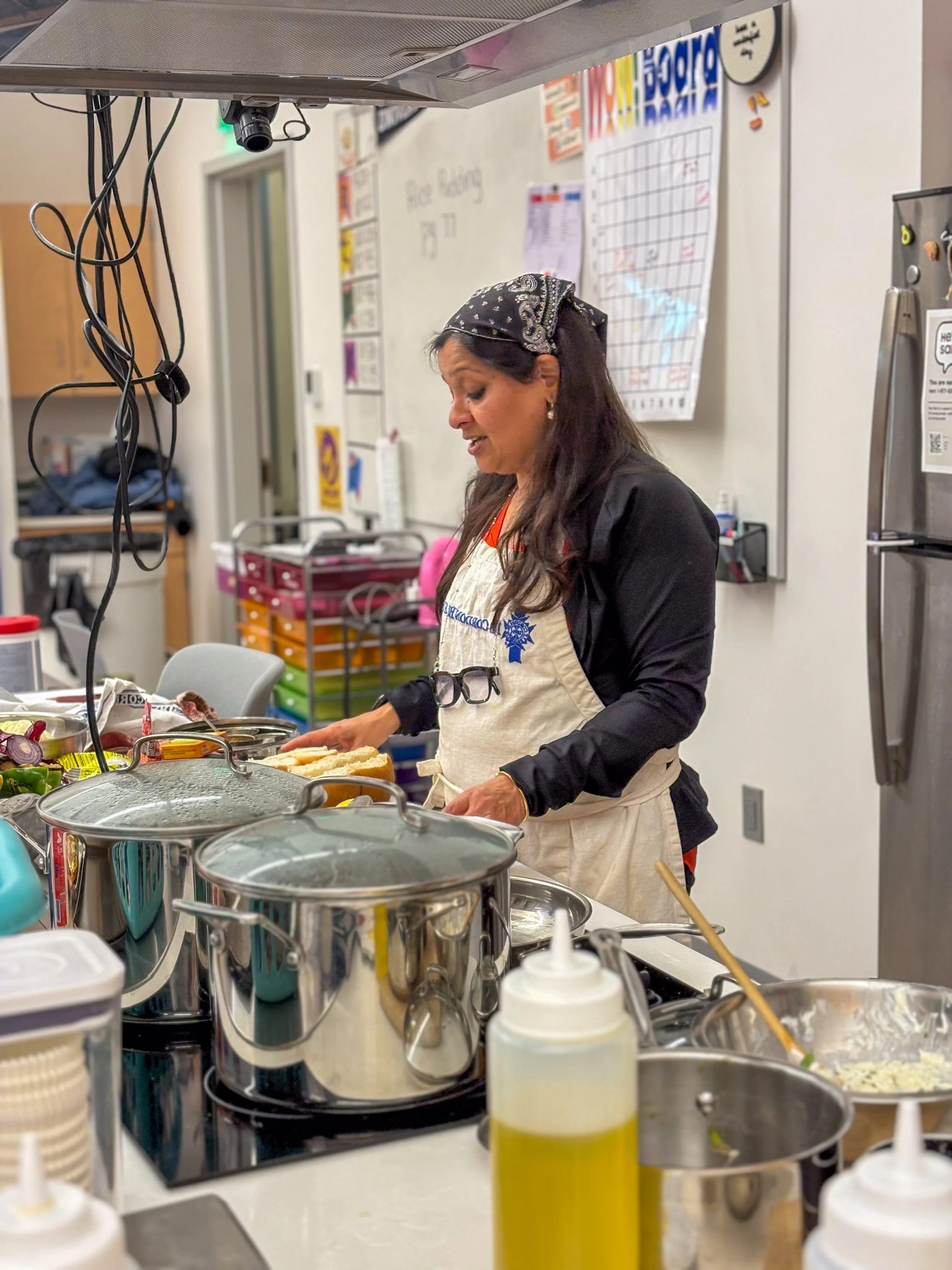 Guest learning traditional Indian cooking techniques during a chef-led culinary class featuring authentic recipes and regional Indian cuisine.