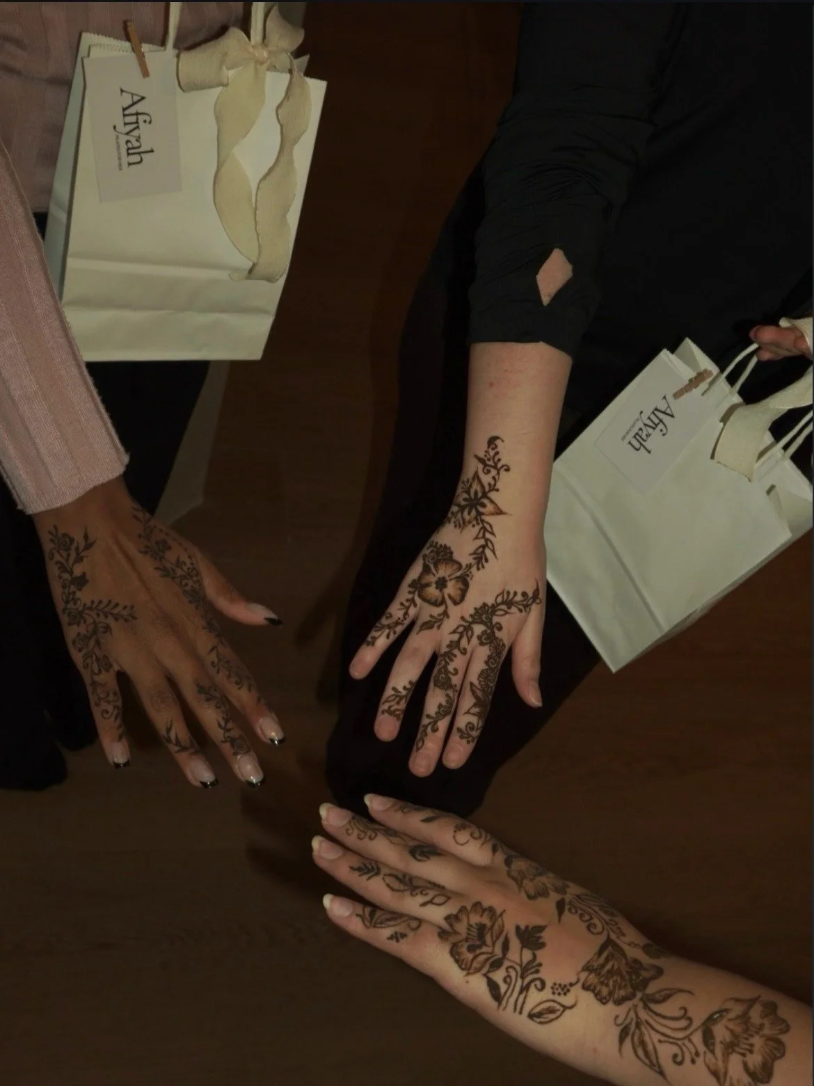 Three hands with black henna at Afiyah Pilates