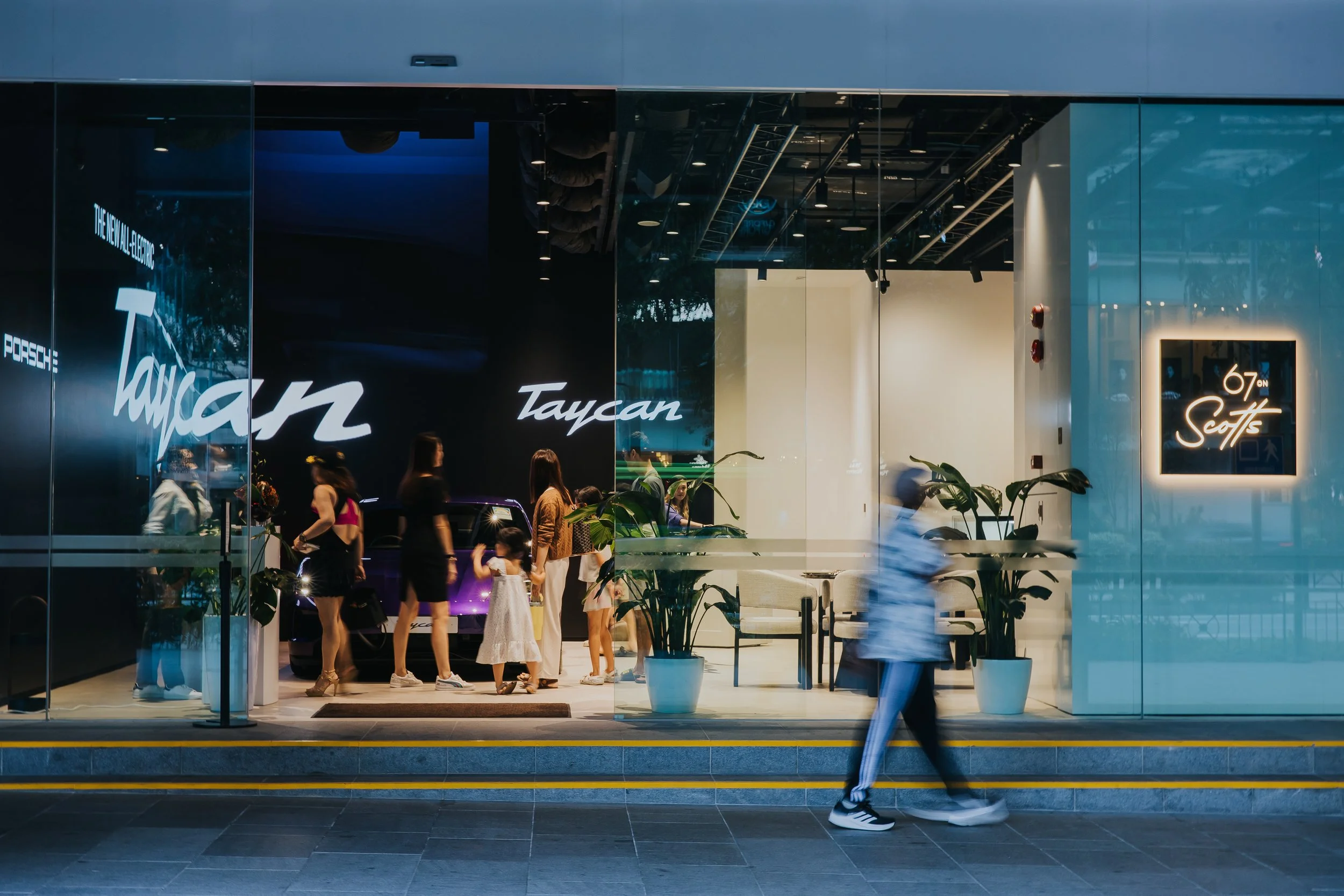 Luxury watch display inside a modern store with several watches showcased in glass cases and framed pictures on the walls.