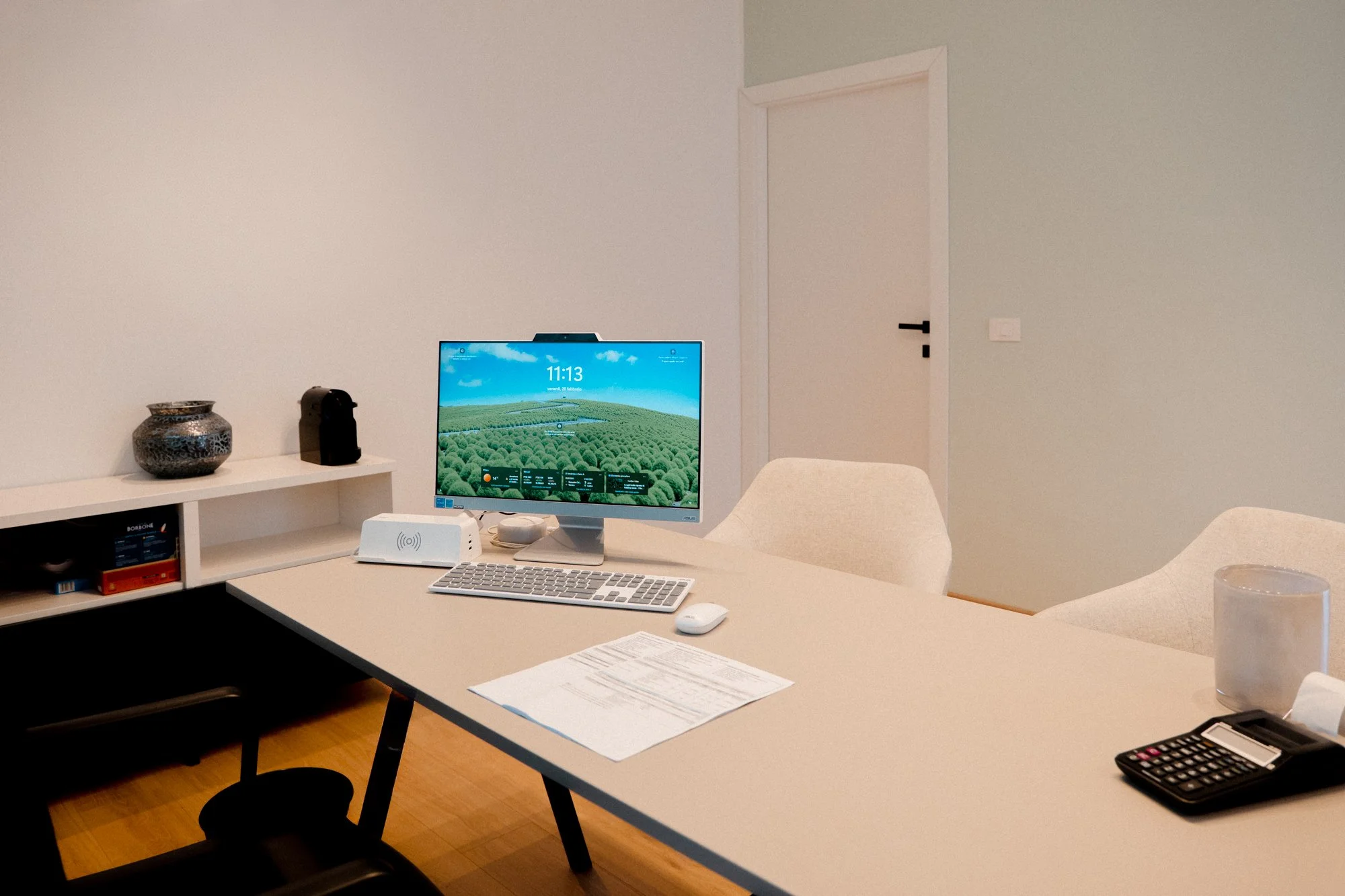 Esempio di spazio ufficio con scrivania, monitor, tastiera, mouse, e vari oggetti decorativi e tecnici