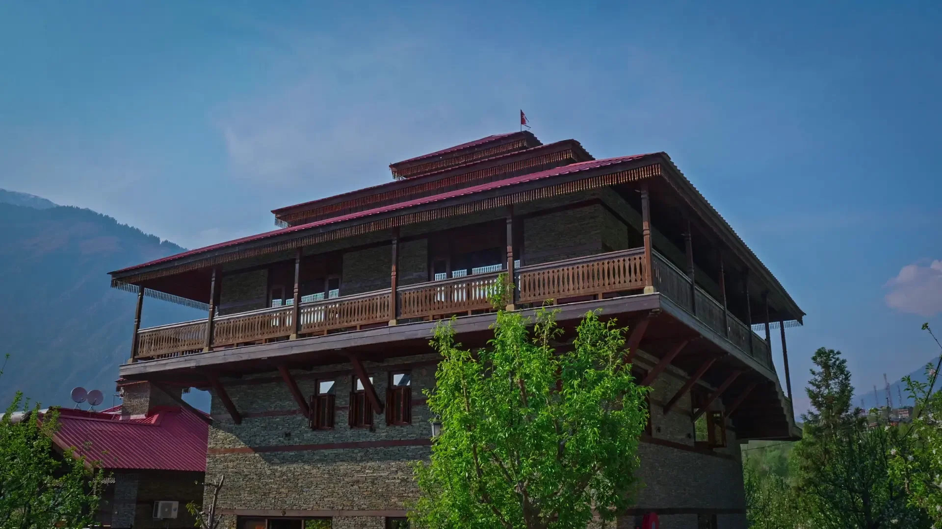 shivadya-main-tower-building-wooden-wrap-around-balcony-stone-facade-himalayan-mountains-manali copy.webp