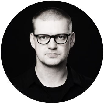Portrait of a man with short-cropped hair, wearing glasses, in black and white.
