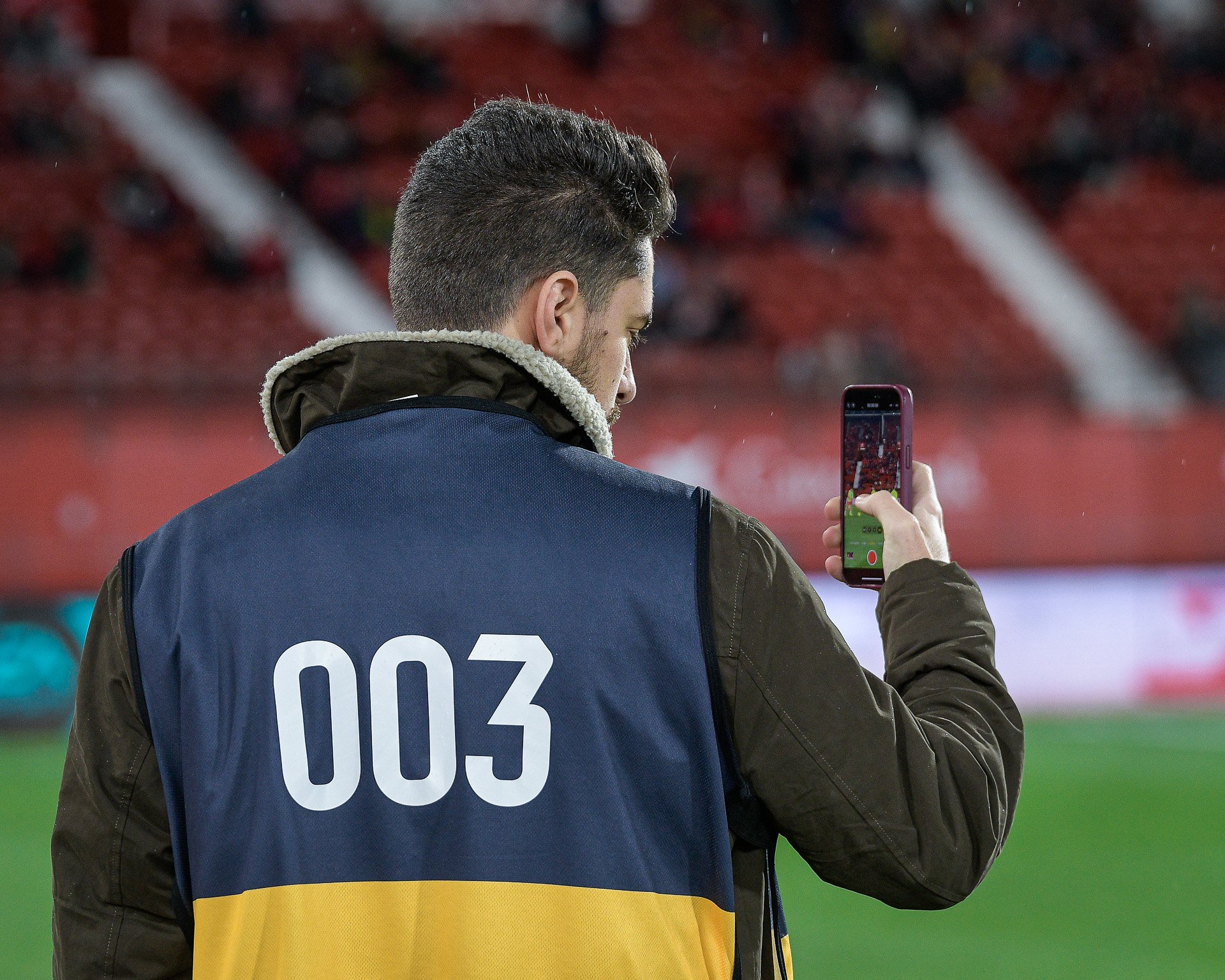 El CEO de CAZORLA Studio, Mario Gómez, trabajando para la UD Almería mientras que toma una foto con un teléfono móvil.