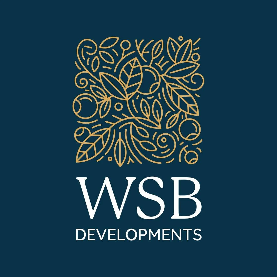 A logo with a dark blue background, featuring a decorative gold line art design of leaves and circles above the text 'WSB DEVELOPMENTS' in white.