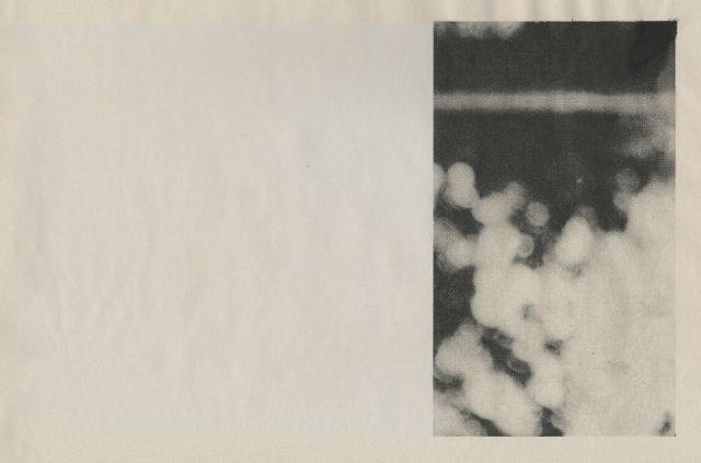 Black and white photo with a dark rectangular shape at the top and a cluster of clouds or smoke below it.