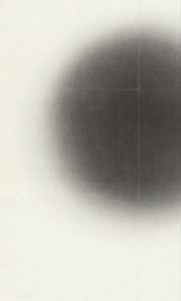 Close-up of a metallic or dark surface with a black spot in the center.