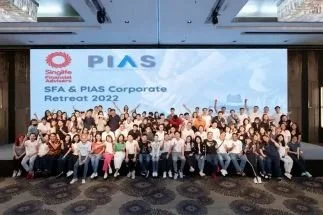 Large group of people gathered for a photo at the SFA & PIAS Corporate Retreat 2022, in front of a large screen.