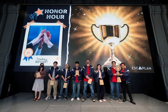 Group of people on stage holding awards during an honor hour event, with a large screen behind them displaying a trophy and the words 'Honor Hour' and 'Today Winner!'.