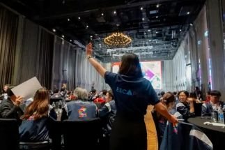 Person giving a presentation to a large audience in a conference room.