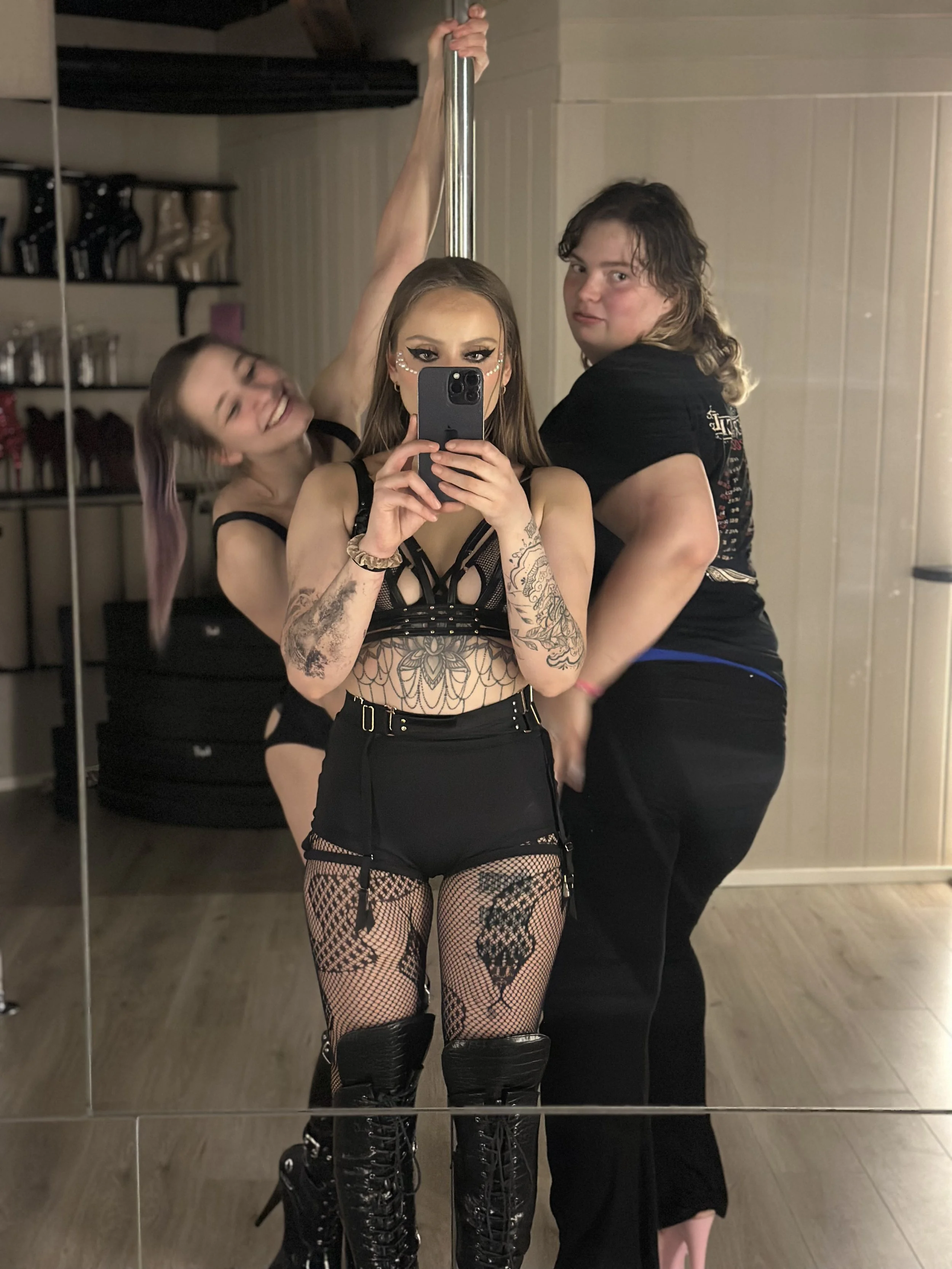 Three people taking a mirror selfie in the studio.