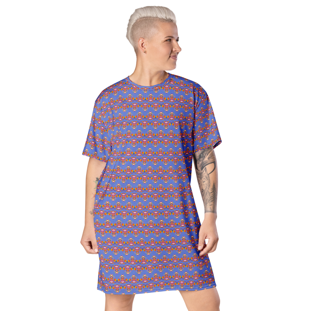 A woman with short platinum blonde hair wearing a loose blue dress with a colorful, intricate pattern, standing and looking to her right. Up Yours Menopause!' merchandise.
