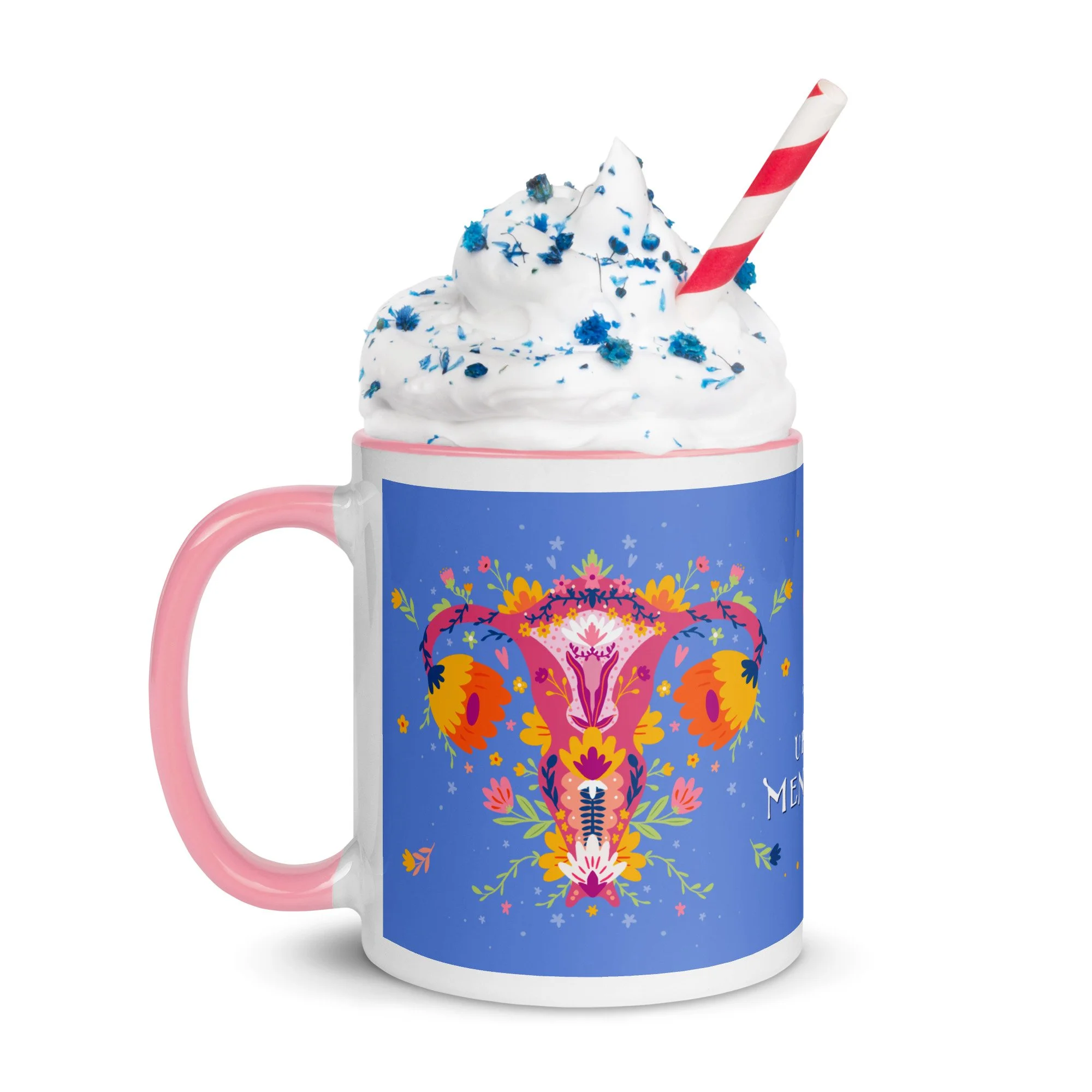 A colorful ceramic mug decorated with a vibrant floral and skull design, filled with whipped cream and topped with blue sprinkles and a red-and-white striped straw. Up Yours Menopause!' merchandise.