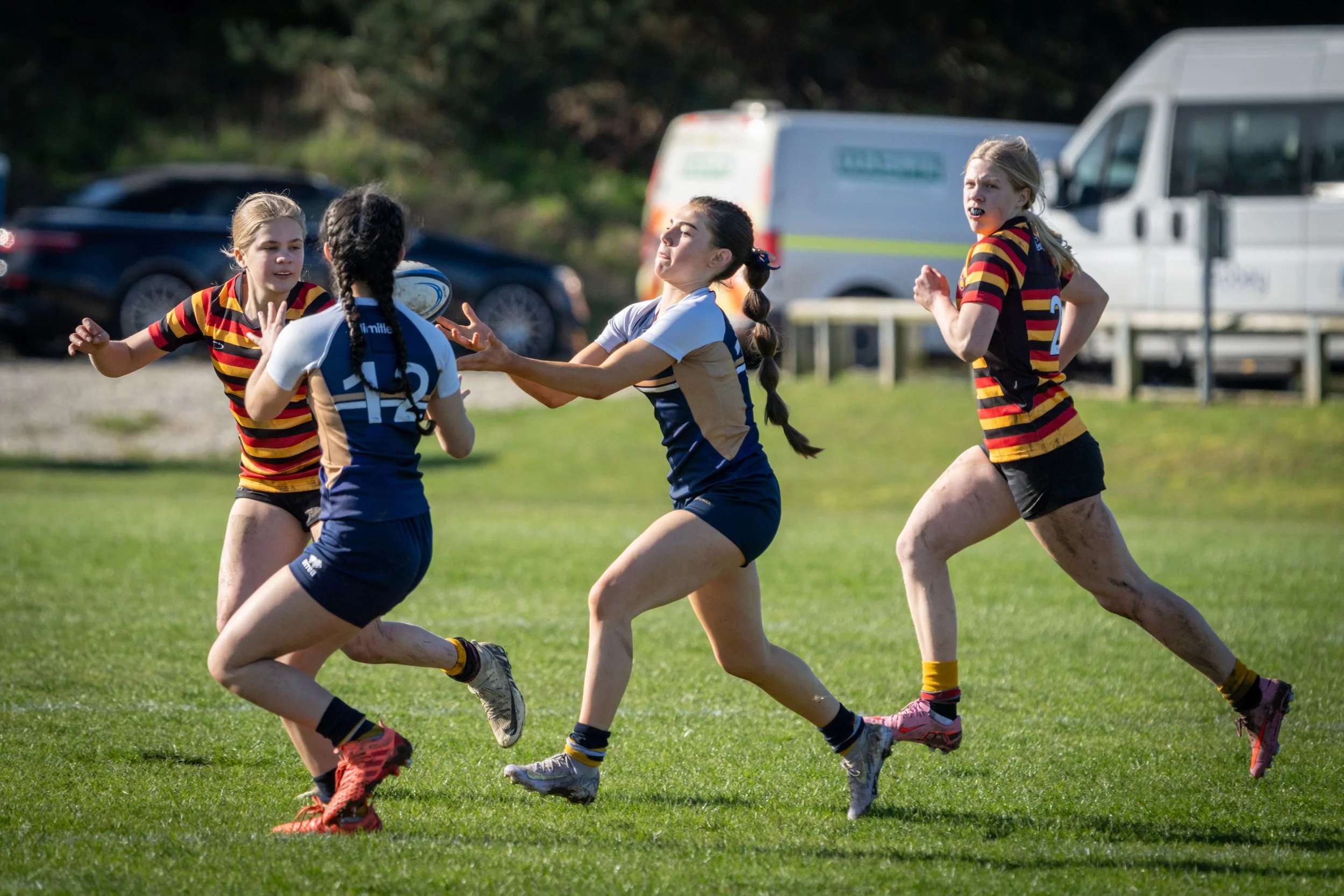 Girls playing rugby on a grassy field