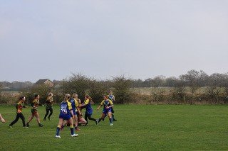 Children running together on a grassy field during daytime.