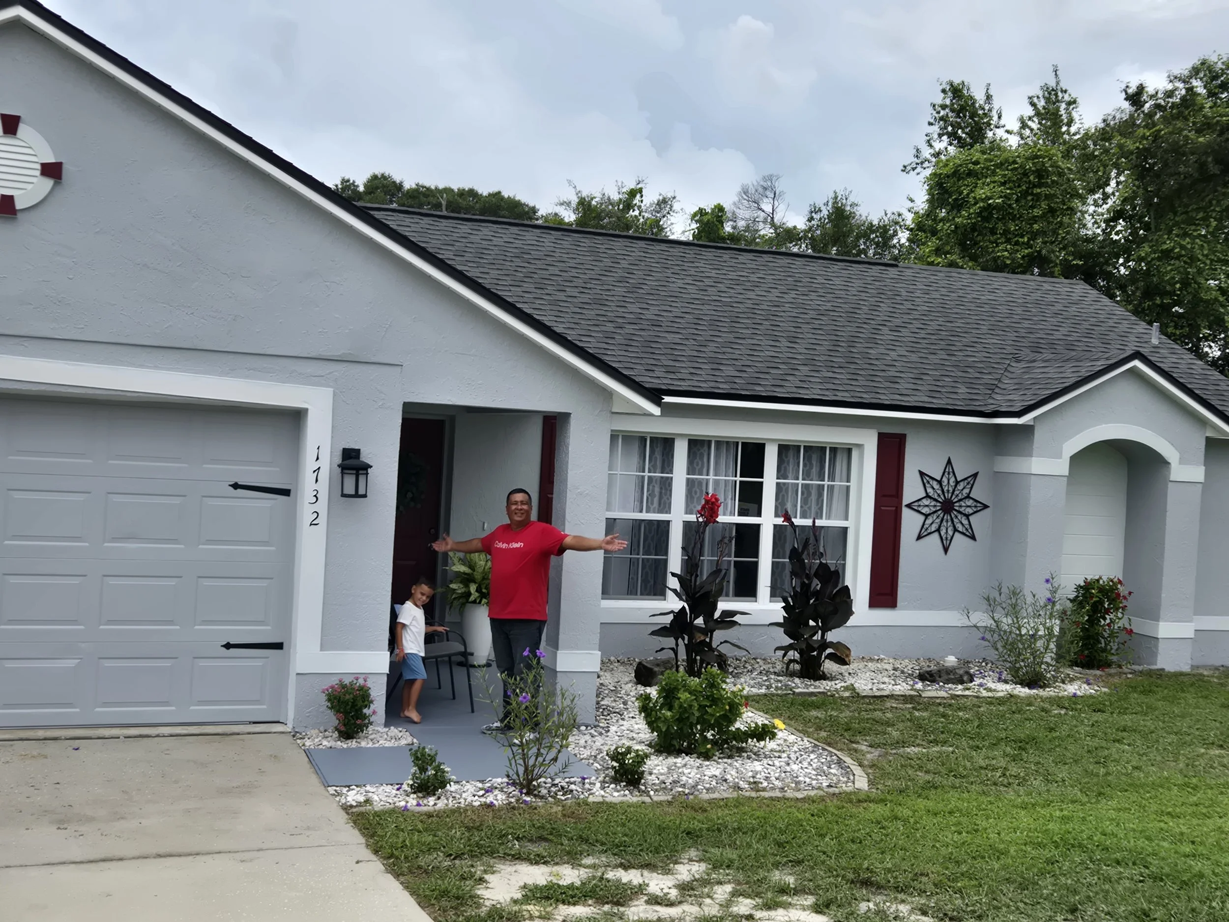 Exterior house painting in Deltona, Florida — freshly painted light gray home with white trim and burgundy shutters by Coats of Quality Painting, trusted family-owned painters in Volusia County