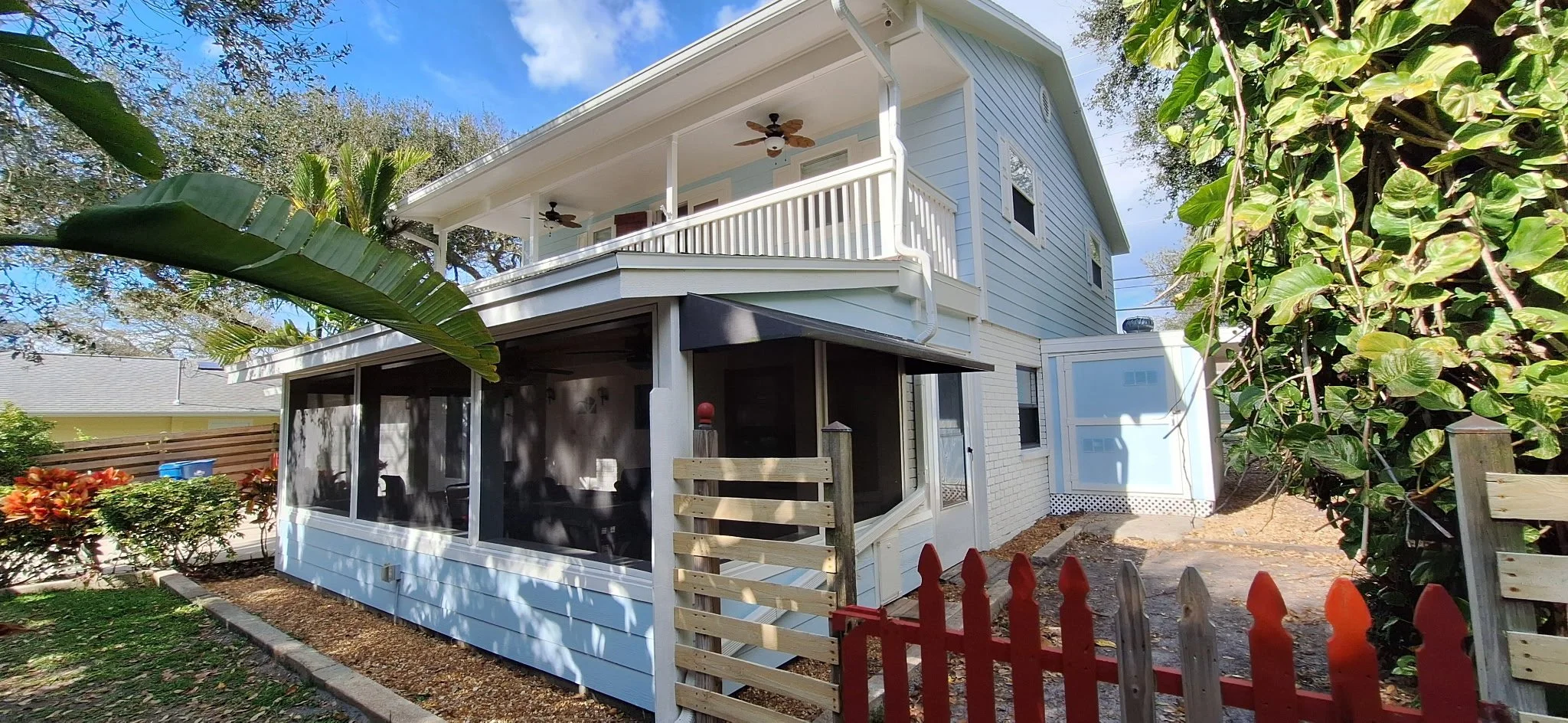 A beautifully painted modern white exterior home in New Smyrna Beach featuring crisp brick, coastal siding, and lush Florida landscaping.