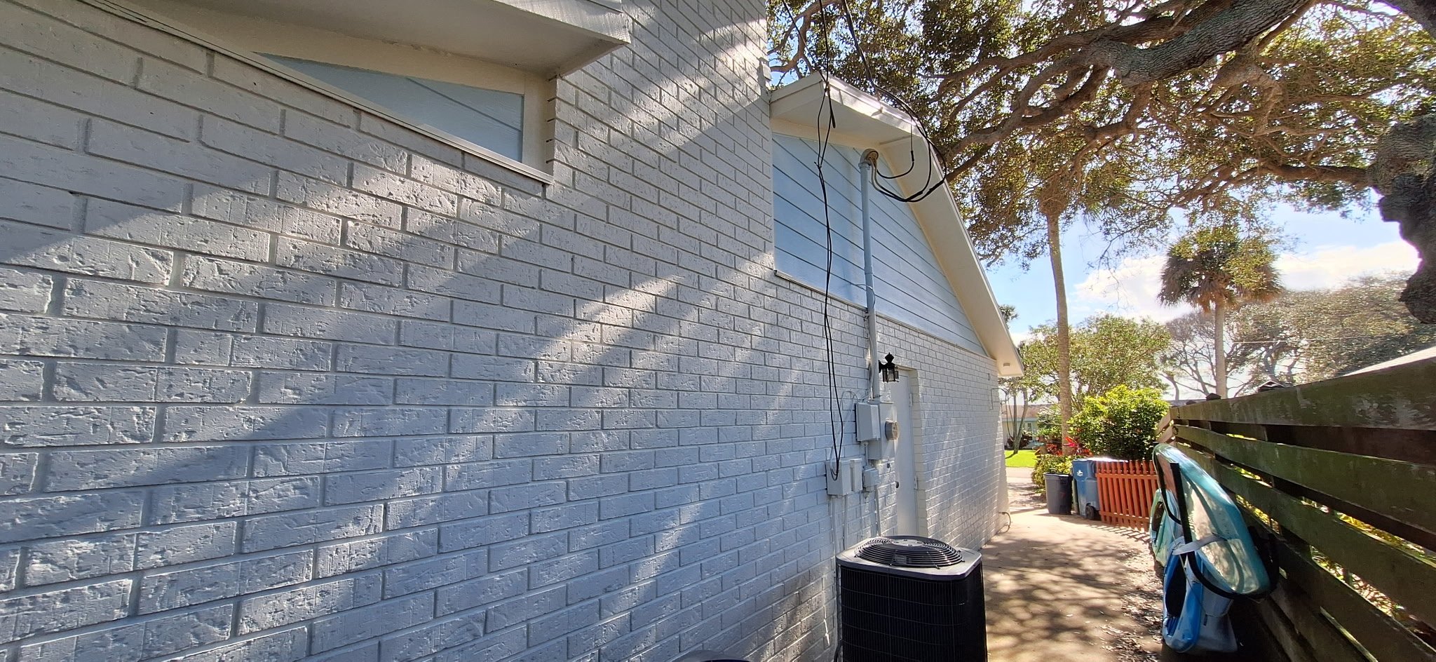 Detailed view of freshly painted white brick along the side of a New Smyrna Beach home, designed for durability and curb appeal.