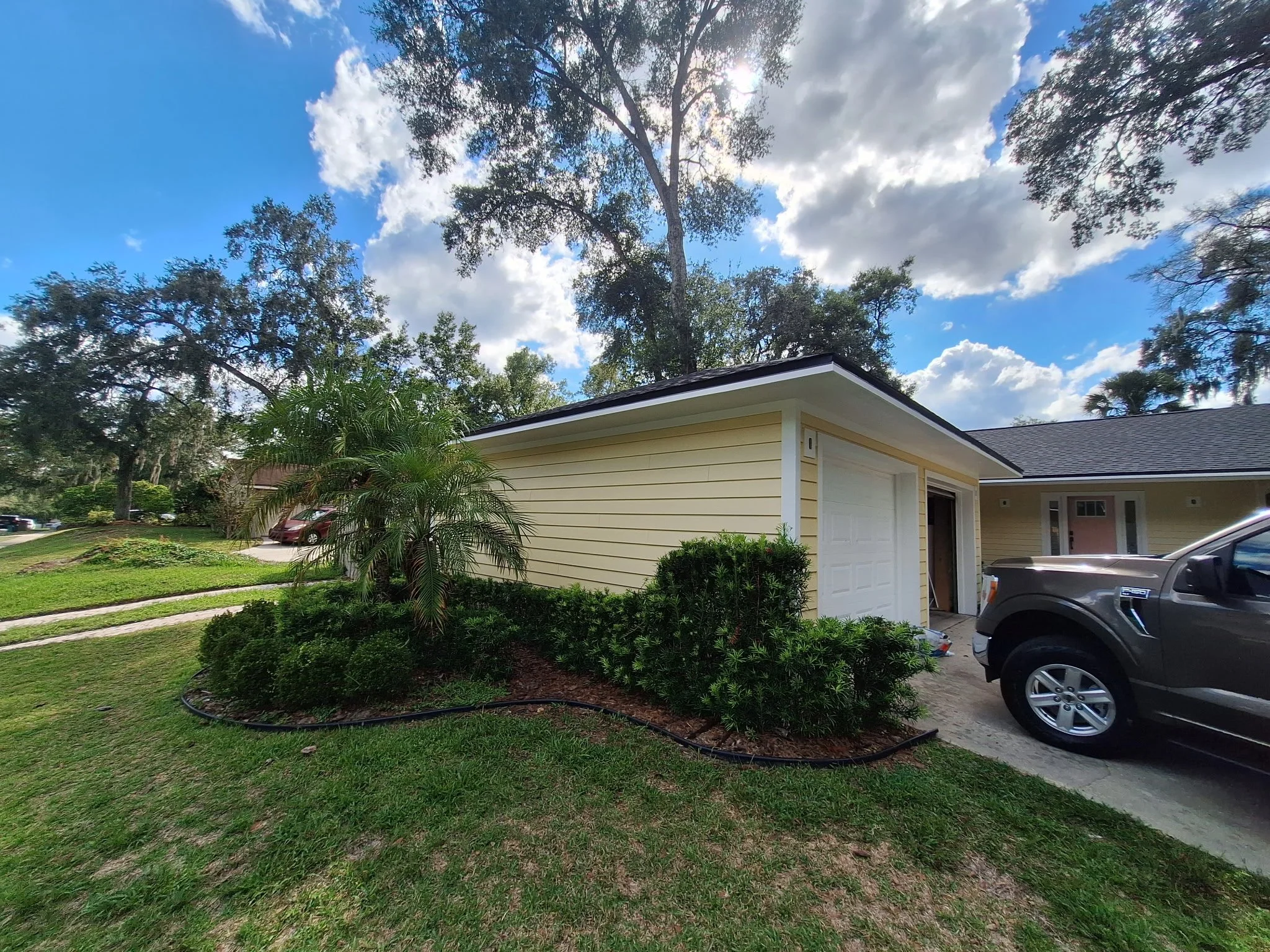 Yellow painted exterior home in Longwood FL with driveway and landscaped front yard