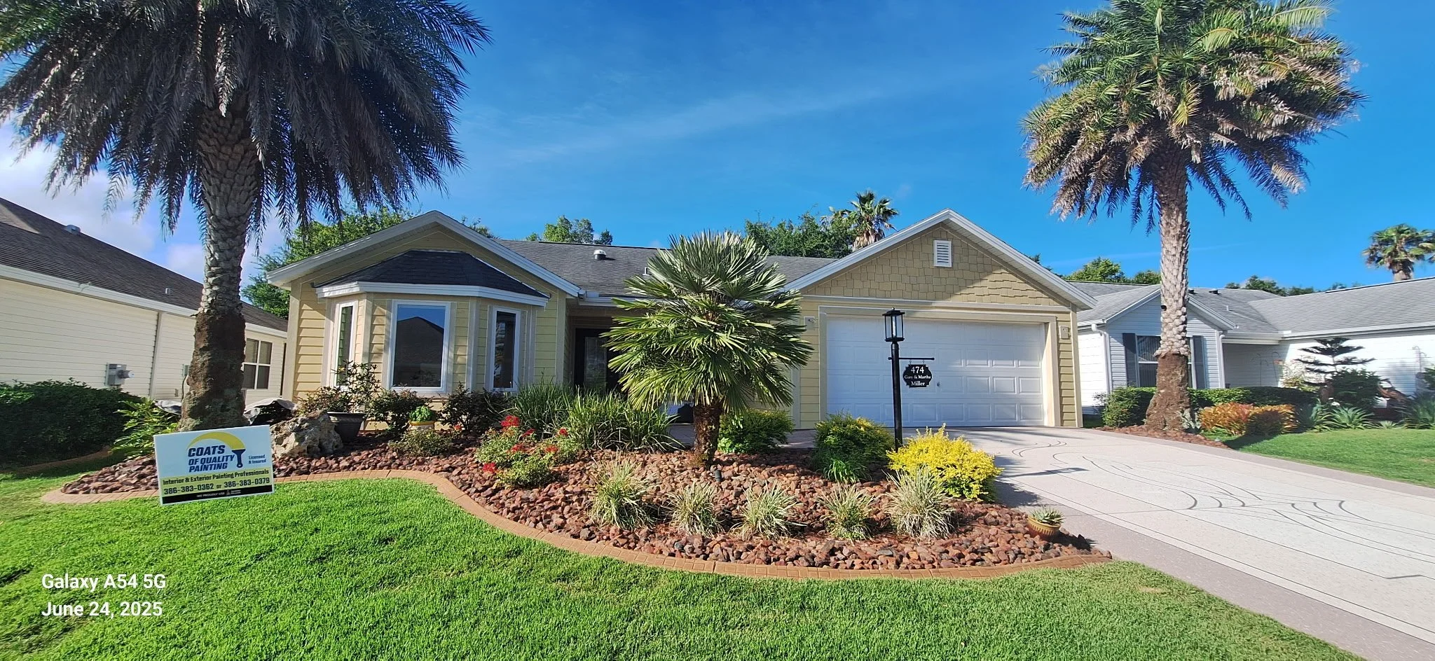 Exterior house painting in Daytona Beach, Florida — freshly painted yellow Hardie Board home with white trim and clean landscaping by Coats of Quality Painting, trusted Volusia County house painters