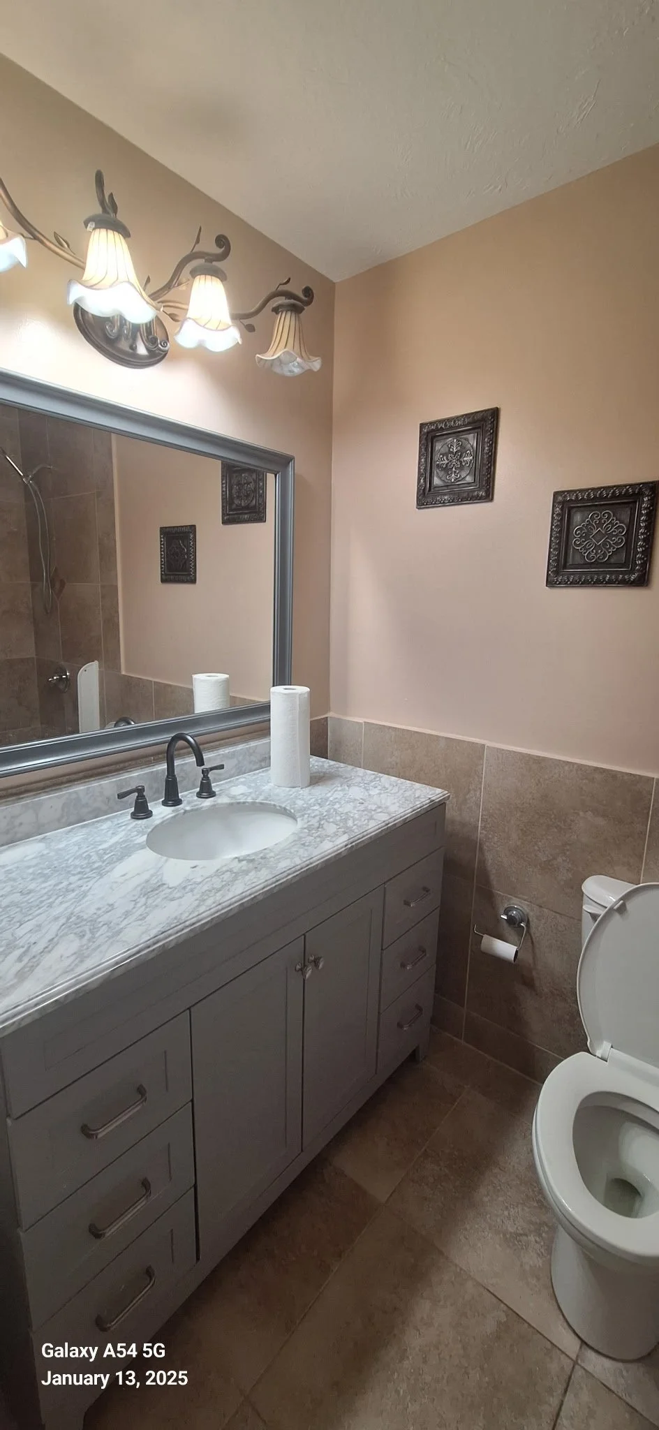 Bathroom cabinet painting, drywall repair, in Volusia County, Florida — gray refinished vanity with marble countertop and updated fixtures by Coats of Quality Painting, serving Daytona Beach, Port Orange, Ormond Beach, New Smyrna Beach, and Deltona